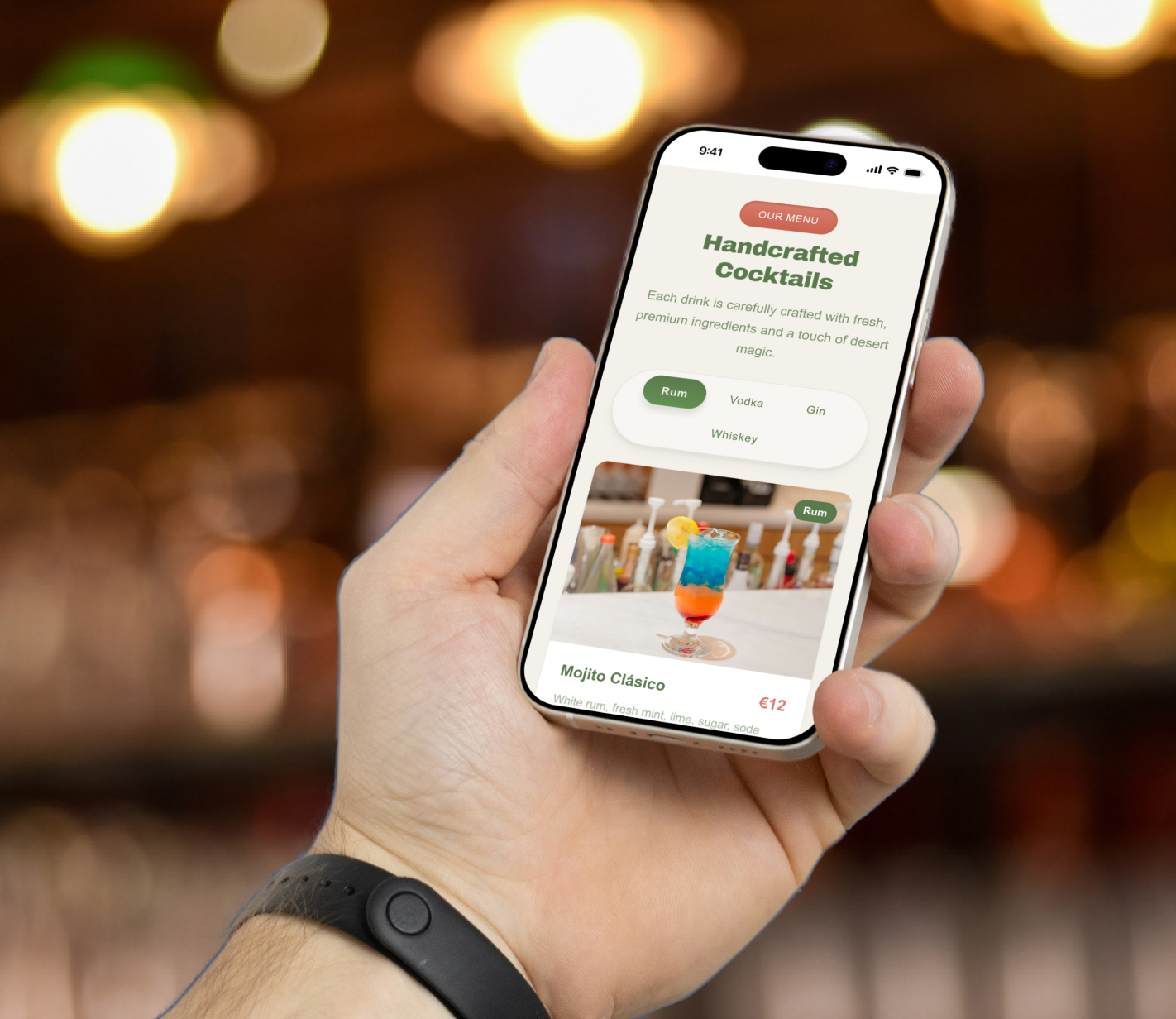 Hand holding a smartphone displaying a digital cocktail menu with drink categories and a colorful cocktail photo.