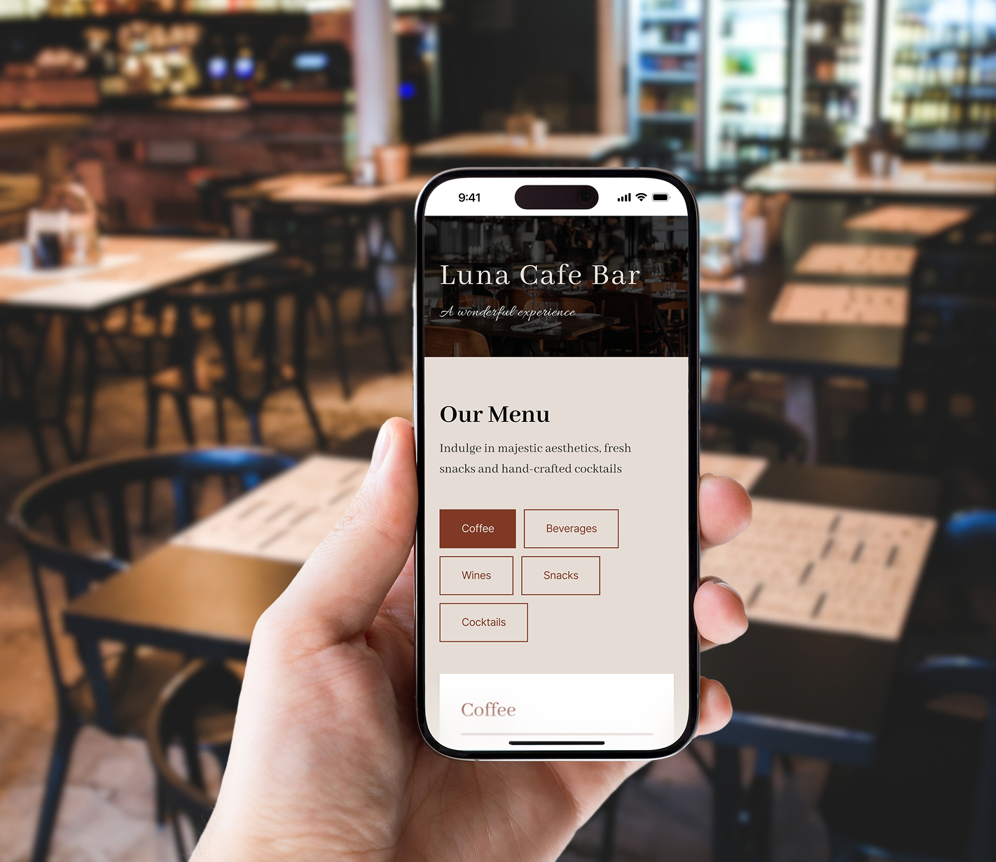 Hand holding a smartphone displaying a digital cafe and bar menu with section buttons for drinks and food, inside a restaurant.